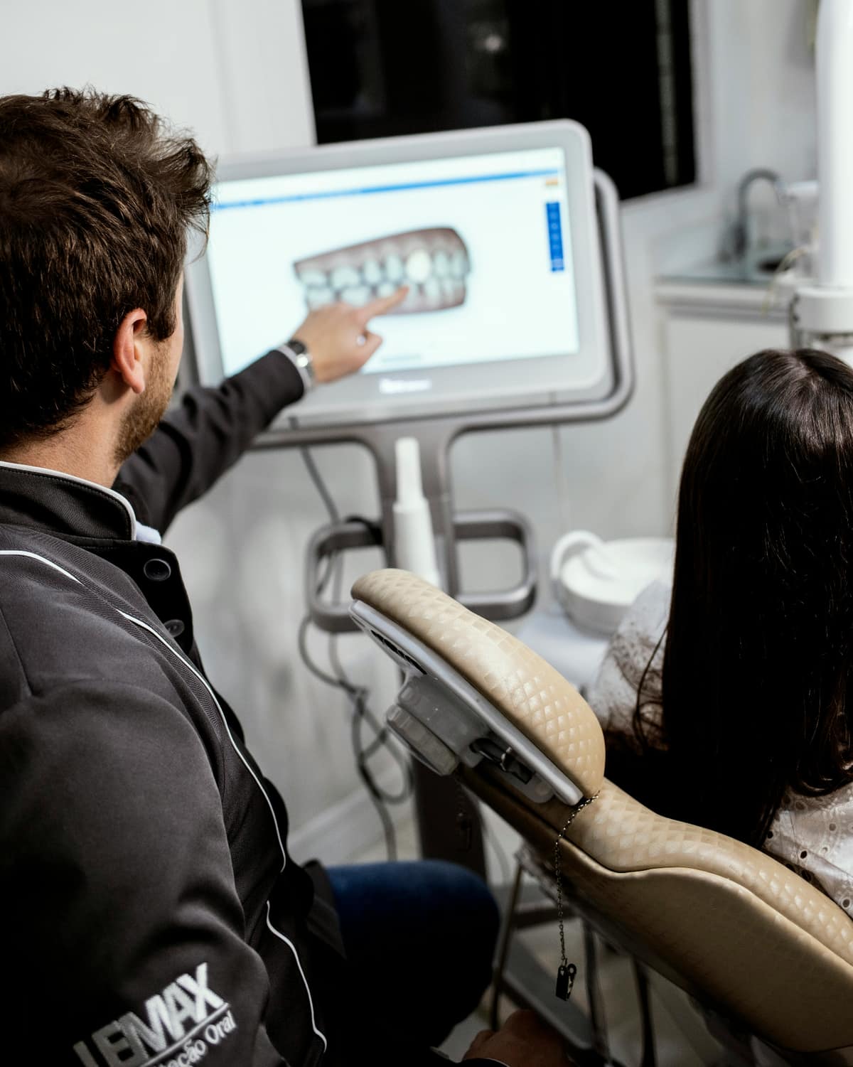Profissional analisando tomografia odontológica em clínica moderna